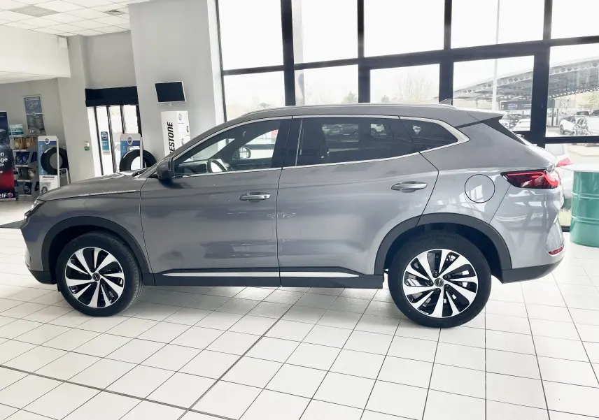 Vue de profil côté gauche d'un SUV BYD SEAL U hybride rechargeable gris Time Grey en showroom, avec jantes bicolores 19 pouces.