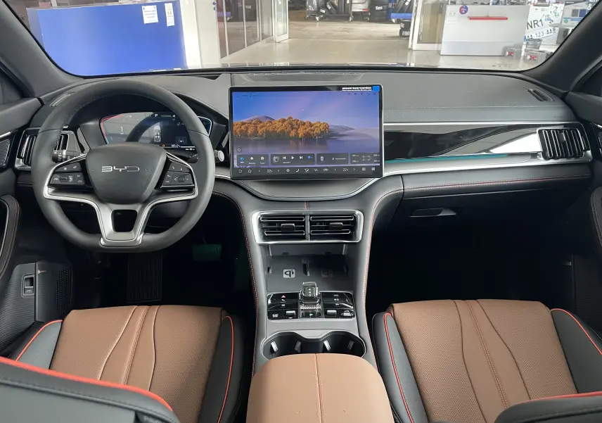 Vue intérieure frontale du BYD SEAL U 2025 avec sellerie marron, grand écran tactile central et volant multifonction noir.