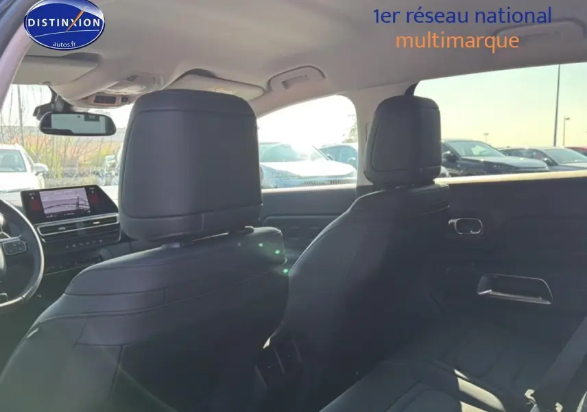 Vue intérieure arrière du Citroën C5 Aircross 2025 bleu eclipse, sièges noirs et tableau de bord avec écran tactile.
