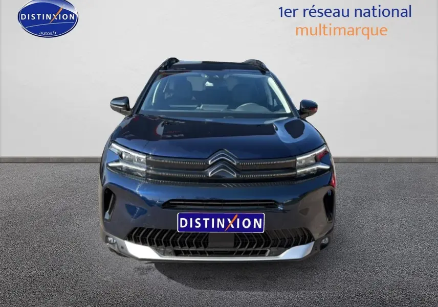 Vue avant d'un Citroën C5 Aircross bleu eclipse avec calandre distinctive et phares LED allumés.