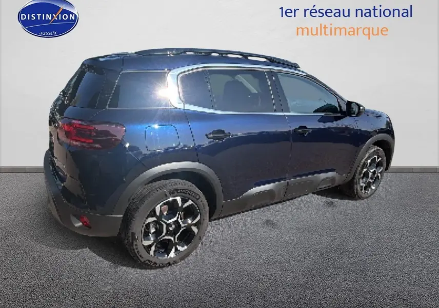 Vue 3/4 arrière droite du Citroën C5 Aircross bleu eclipse avec jantes alu et barres de toit noires.