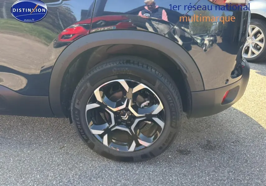 Gros plan sur la roue arrière droite d'un Citroën C5 Aircross bleu eclipse avec jante alu noire et argentée.