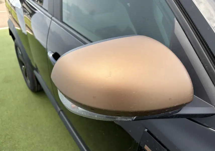 Rétroviseur droit brun cuivré sur Dacia Bigster noir, vue rapprochée côté avant du véhicule.