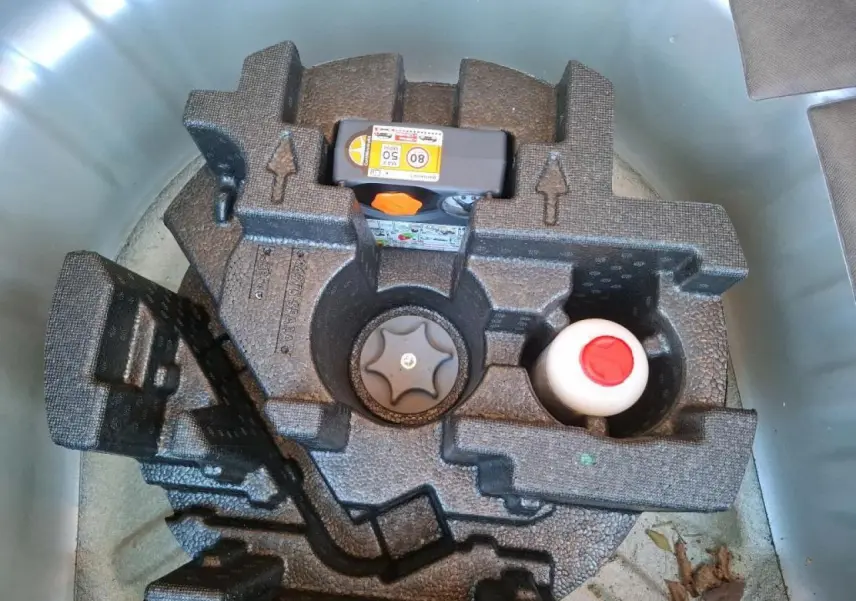 Gros plan sur le kit de réparation pneumatique dans le coffre d'une Nissan Micra gris clair 2022.