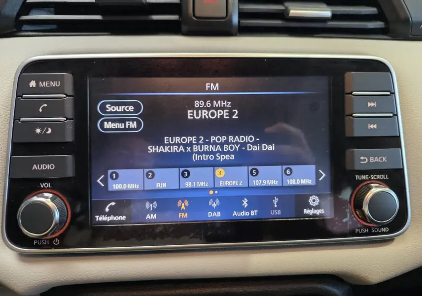 Vue rapprochée de l’écran tactile multimédia 7 pouces de la Nissan Micra Business Edition 2022, tableau de bord beige.