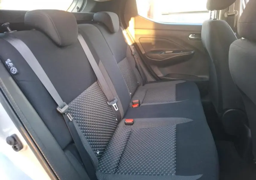 Vue intérieure côté gauche de la banquette arrière tissu noir de la Nissan Micra gris clair avec ceintures de sécurité visibles.