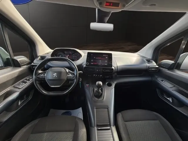 Vue intérieure avant du Peugeot Rifter gris foncé 2020, tableau de bord avec écran tactile et volant cuir multifonctions.
