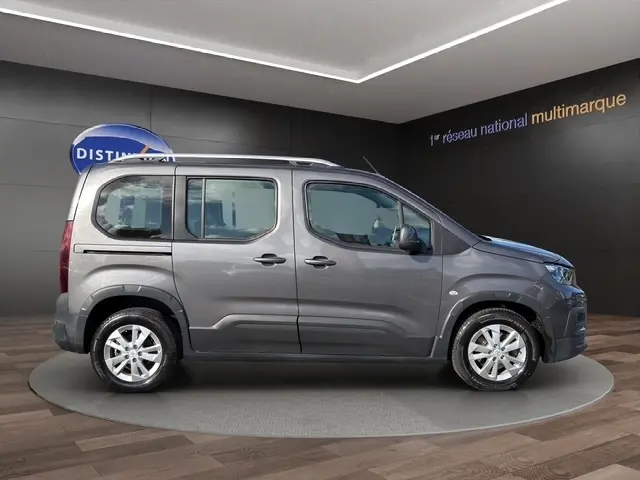 Vue latérale droite d’un Peugeot Rifter gris foncé 2020, avec portes coulissantes et jantes alliage visibles.