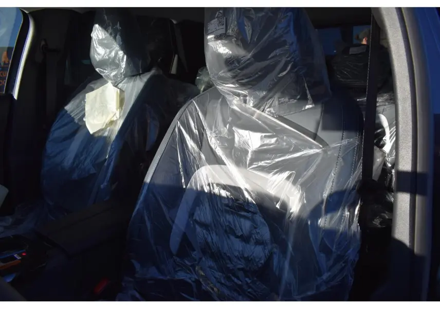 Gros plan sur les sièges avant protégés par des housses plastiques dans l'habitacle du Citroën C5 Aircross gris.