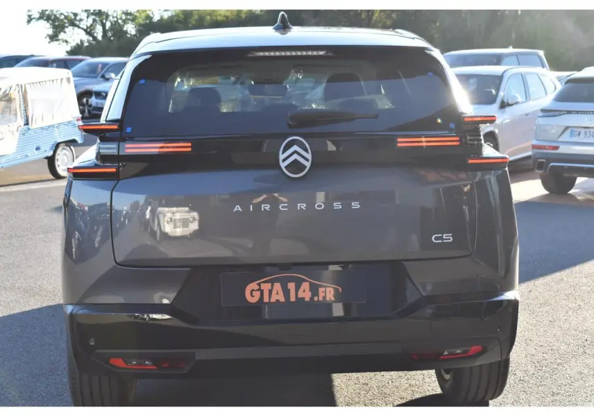 Vue arrière d'un Citroën C5 Aircross gris métallisé avec feux arrière horizontaux et toit bi-ton noir Perla Nera.