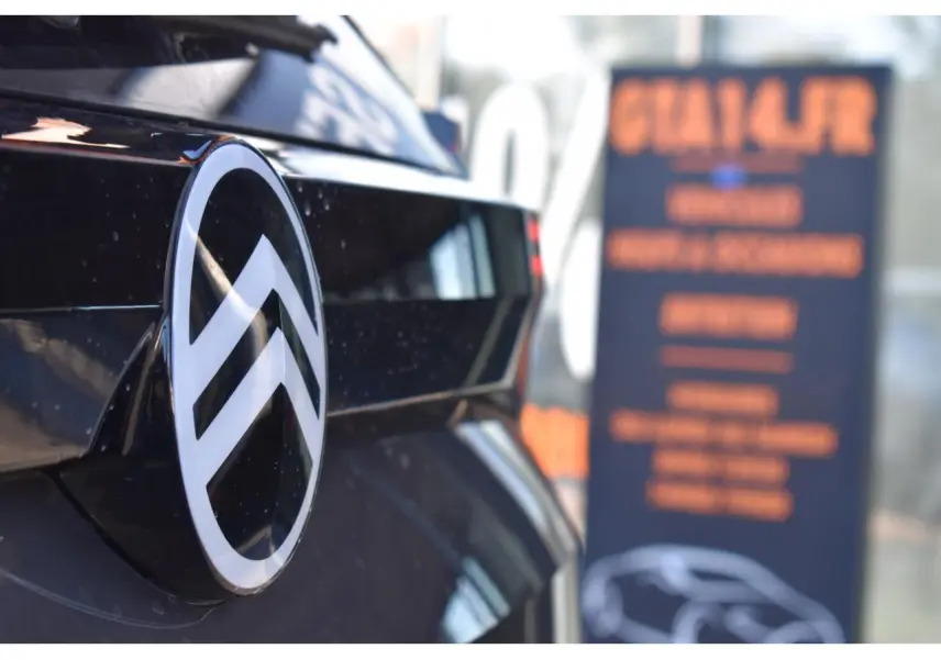 Gros plan sur l'arrière noir brillant d'un Citroën C5 Aircross avec le logo chromé en relief.