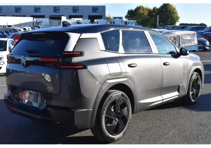 Vue 3/4 arrière droite du Citroën C5 Aircross gris métallisé avec toit bi-ton noir et jantes noires.