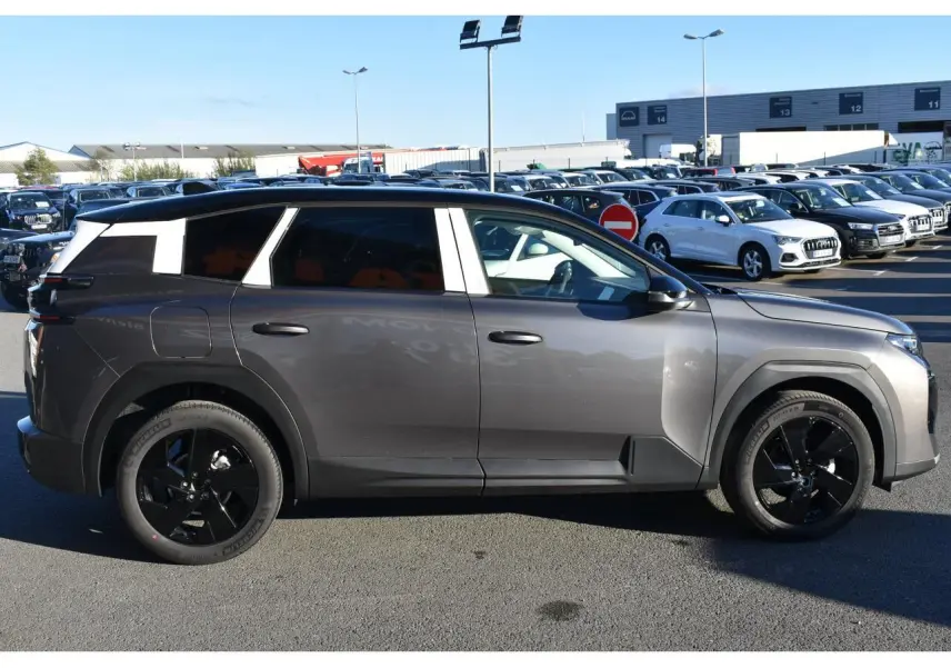 Profil droit d'un Citroën C5 Aircross gris métallisé 2026 avec toit bi-ton noir et jantes noires.