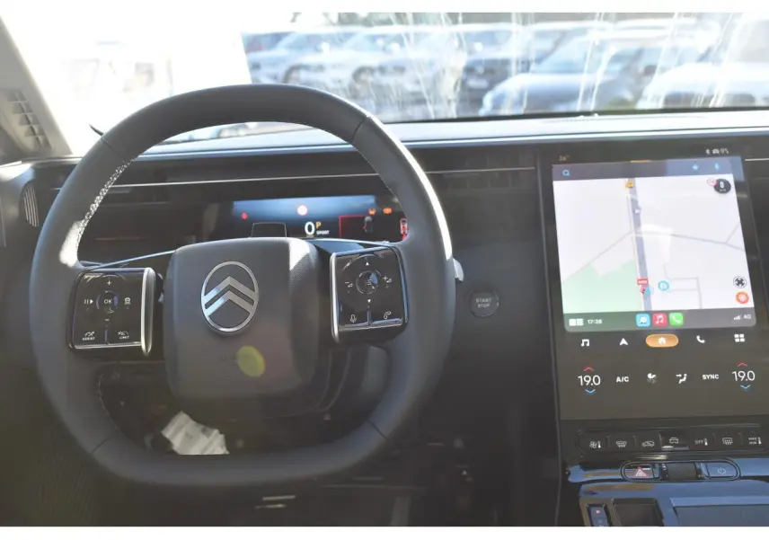 Vue intérieure centrée sur le volant Citroën et l'écran tactile du tableau de bord du C5 Aircross gris.