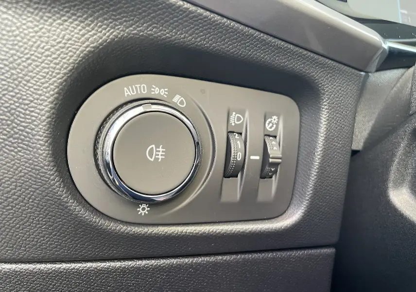 Commande des phares et réglages d'éclairage sur tableau de bord noir de l'Opel Mokka 2023 côté gauche du conducteur.