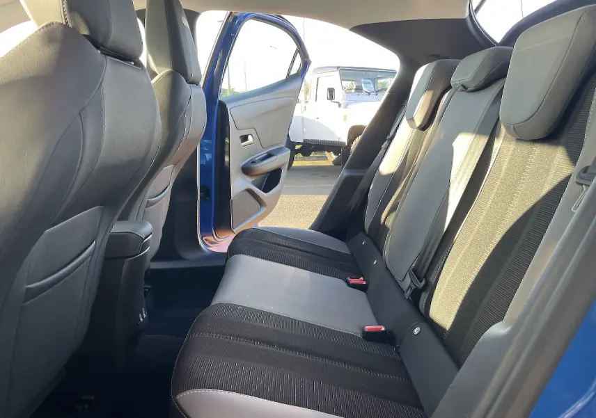 Vue intérieure côté gauche des sièges arrière en tissu gris et noir de l'Opel Mokka bleu Voltak 2023 avec porte ouverte.