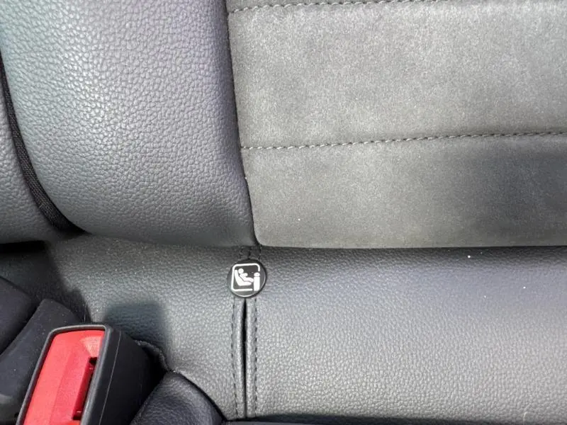 Gros plan sur la fixation ISOFIX noire sur la banquette arrière en tissu gris et cuir noir du SEAT Arona 2022.