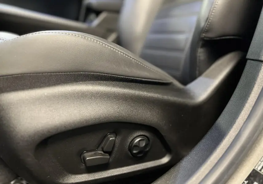 Détail des commandes de réglage électrique du siège en cuir noir côté conducteur de l'Alfa Romeo Tonale 2022.