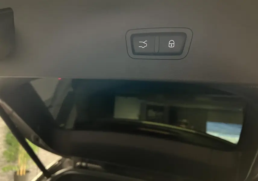 Bouton d'ouverture et de verrouillage du hayon électrique sur le coffre d'une Alfa Romeo Tonale gris foncé.