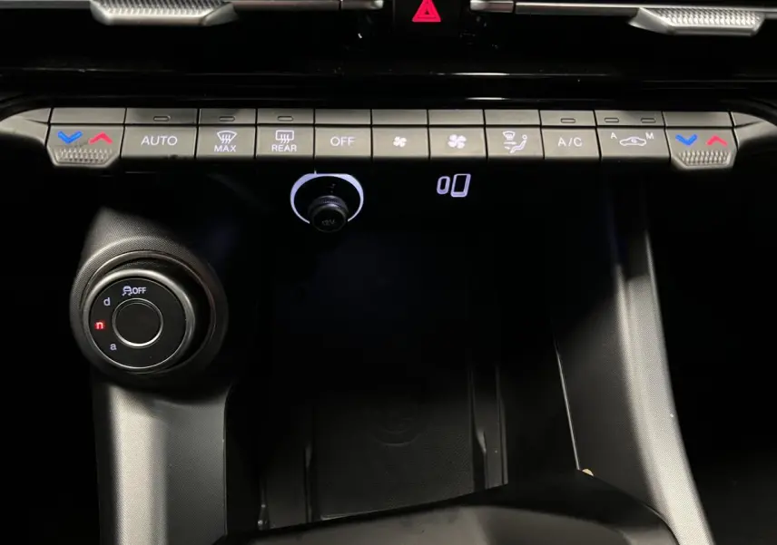 Vue rapprochée de la console centrale noire de l'Alfa Romeo Tonale 2022 avec commandes climatisation et molette de sélection.