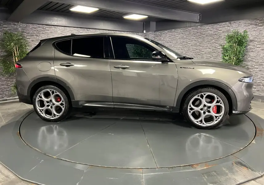 Profil droit de l'Alfa Romeo Tonale 1.5 mHEV gris foncé avec jantes 20 pouces et étriers Brembo rouges visibles.