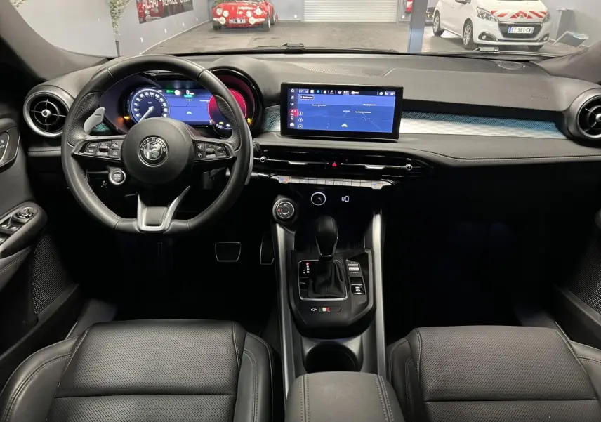 Intérieur noir de l'Alfa Romeo Tonale 2022, vue frontale sur le volant cuir et l'écran tactile central.