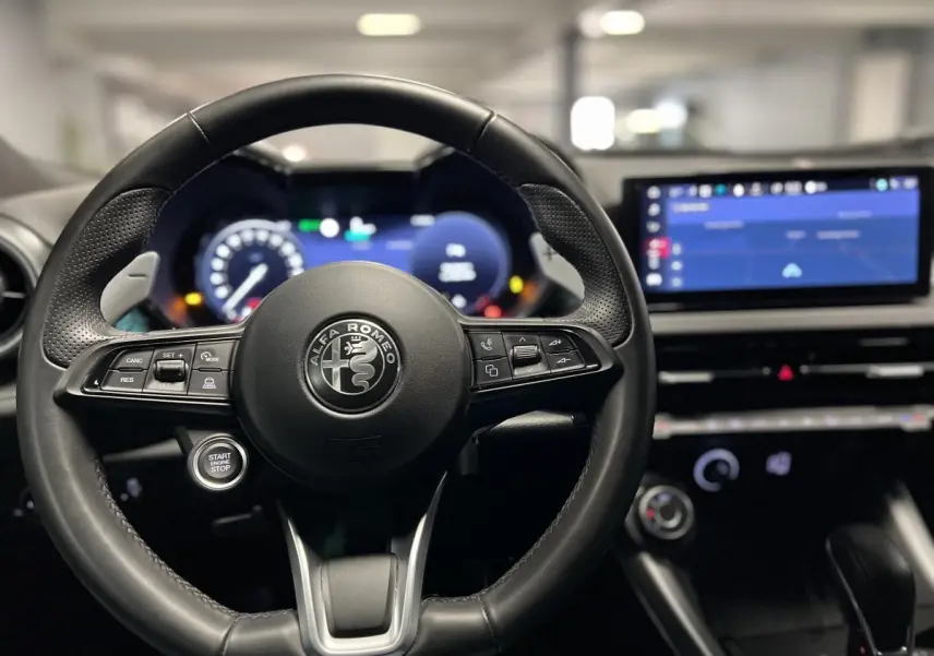 Volant cuir noir de l'Alfa Romeo Tonale 2022 avec tableau de bord digital et écran tactile central visible de face.