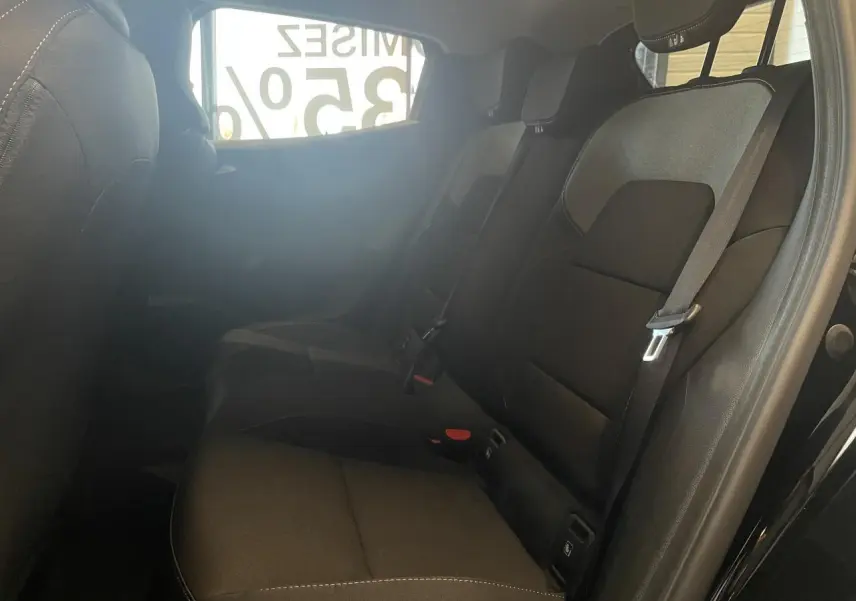 Vue intérieure côté droit des sièges arrière noirs de la Renault Clio 1.5 Blue dCi 2025 avec ceintures de sécurité visibles.