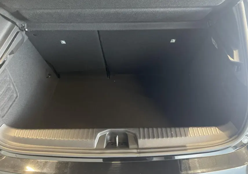 Coffre ouvert vu de face d'une Renault Clio 1.5 Blue dCi 2025 noir étoilé avec seuil de chargement visible.