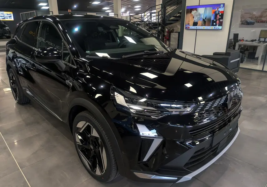 Vue 3/4 avant d’un Renault SYMBIOZ E-Tech full hybrid noir étoilé, avec calandre et phares LED distinctifs en showroom.