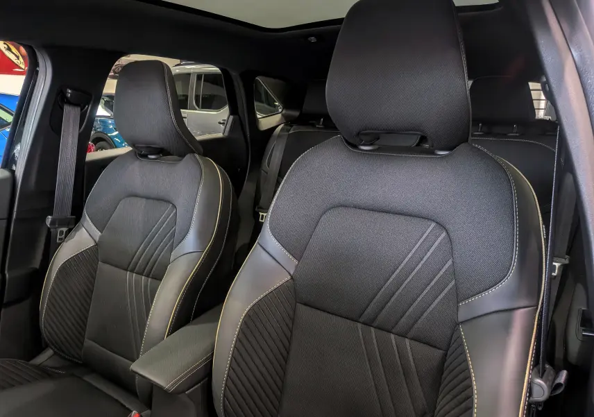 Vue intérieure rapprochée des sièges avant en tissu et cuir noir étoilé avec surpiqûres contrastantes dans une Renault Symbioz E-Tech 2026.