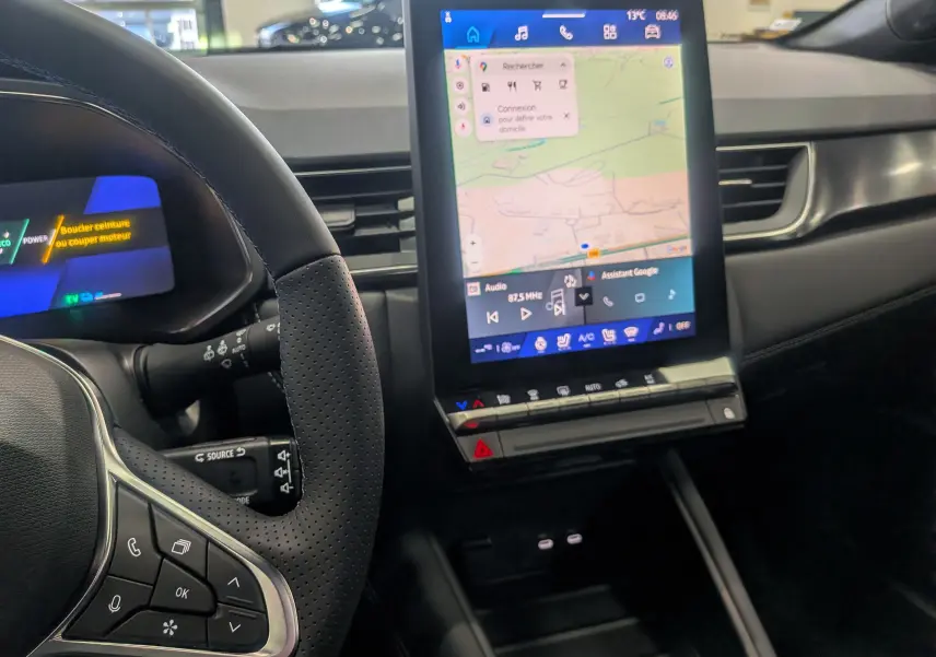 Vue rapprochée de l’intérieur du Renault Symbioz 2026, écran tactile central affichant la navigation, volant noir perforé.
