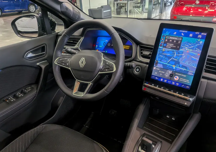 Vue intérieure côté conducteur du Renault Symbioz E-Tech noir étoilé, avec tableau de bord numérique et grand écran tactile vertical.