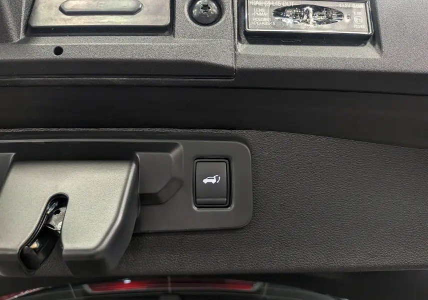 Gros plan sur le bouton d'ouverture du coffre arrière dans le hayon noir étoilé du Renault Symbioz E-Tech 2026.