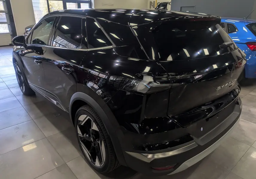 Vue 3/4 arrière droite du Renault SYMBIOZ noir étoilé, soulignant ses lignes modernes et ses jantes bicolores.