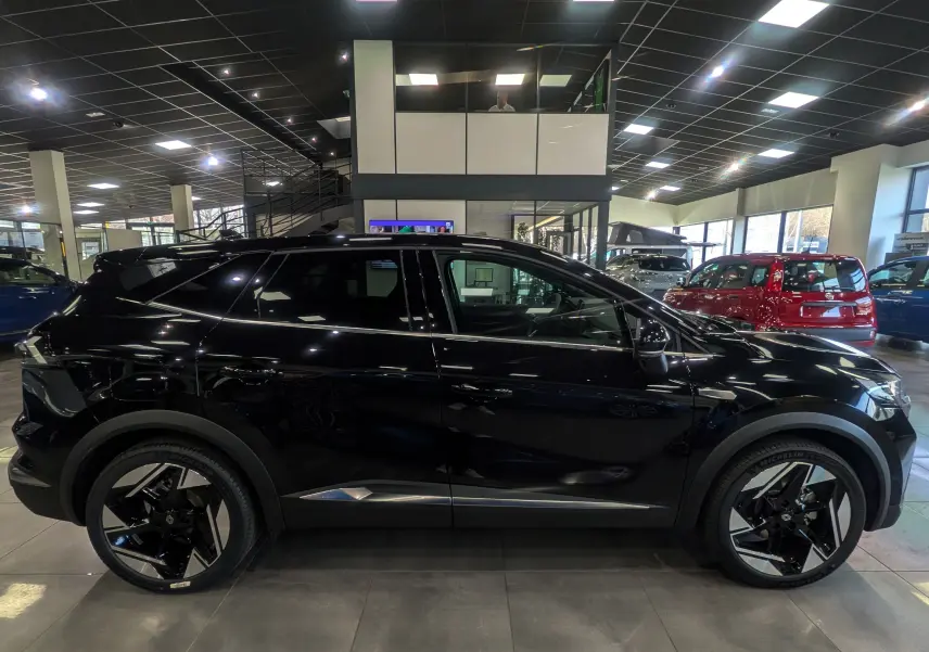 Profil droit du Renault SYMBIOZ E-Tech full hybrid noir étoilé, avec jantes noires et détails chromés en concession.