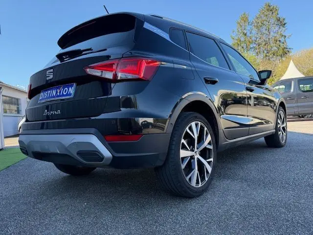 Vue 3/4 arrière droite du SEAT Arona noir avec toit gris, jantes alliage 18 pouces et feux arrière LED distinctifs.