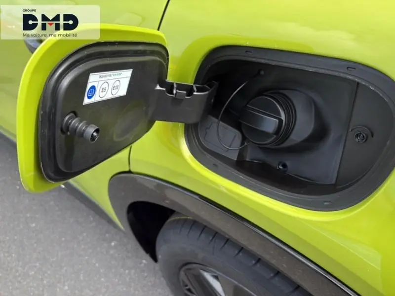 Gros plan sur la trappe de carburant ouverte côté gauche d'une FIAT 600 vert Méditerranéen métallisé.