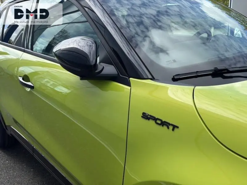 Vue rapprochée du côté gauche avant d’une FIAT 600 Sport vert Méditerranéen métallisé avec toit noir et logo Sport noir.