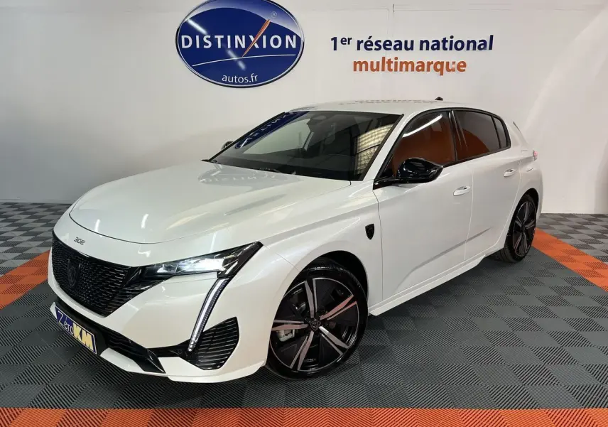 Peugeot 308 GT PHEV blanc nacré vue 3/4 avant droit avec jantes noires et détails noirs brillants.