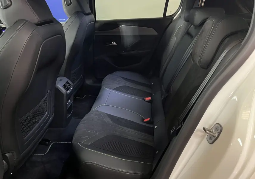Vue latérale des sièges arrière en cuir noir avec surpiqûres blanches du Peugeot 308 GT PHEV blanc nacré 2022.