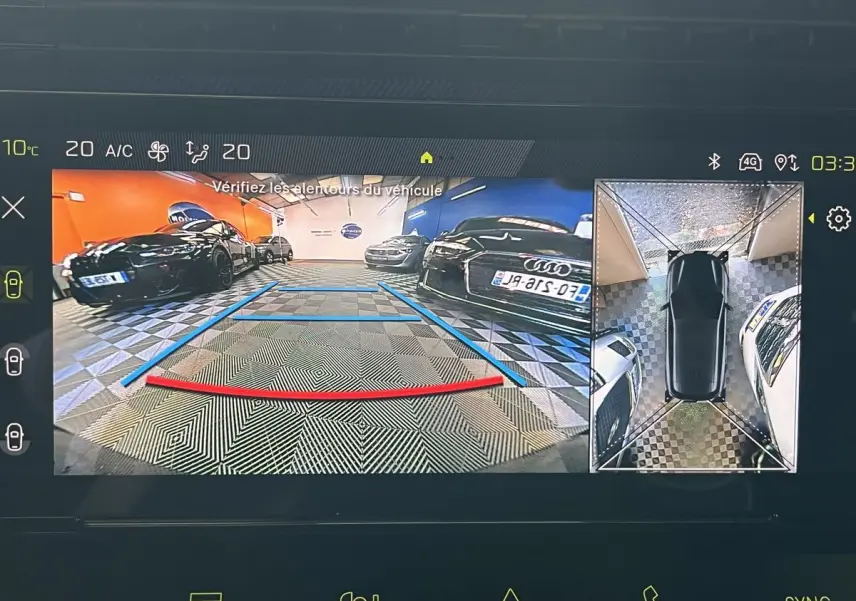 Affichage caméra 360° et recul montrant un parking intérieur avec plusieurs voitures, vue arrière du véhicule en stationnement.