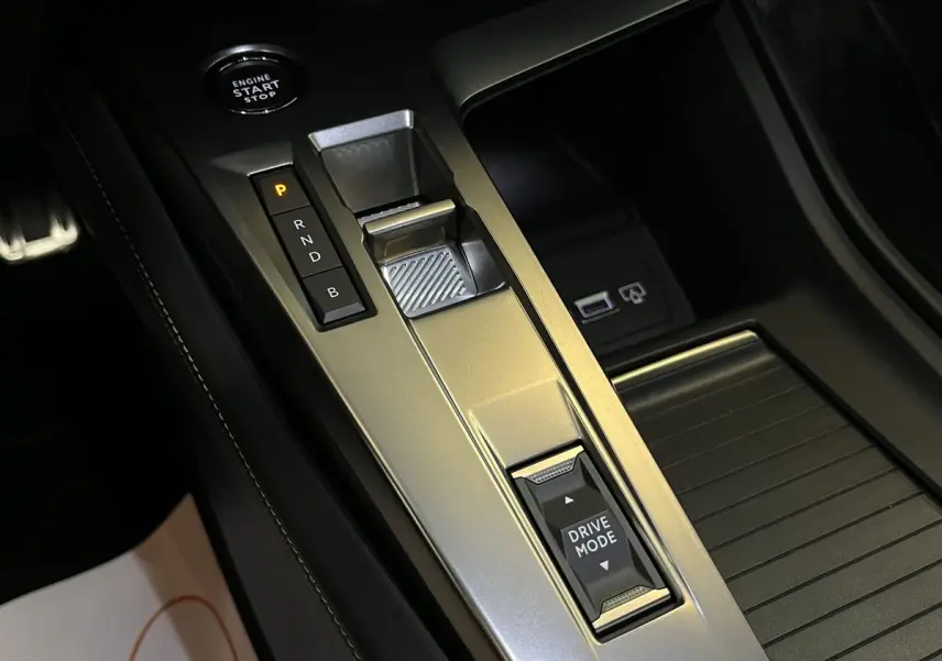 Gros plan sur la console centrale de la Peugeot 308 GT PHEV 180 EAT8 avec levier de vitesses et bouton Drive Mode.