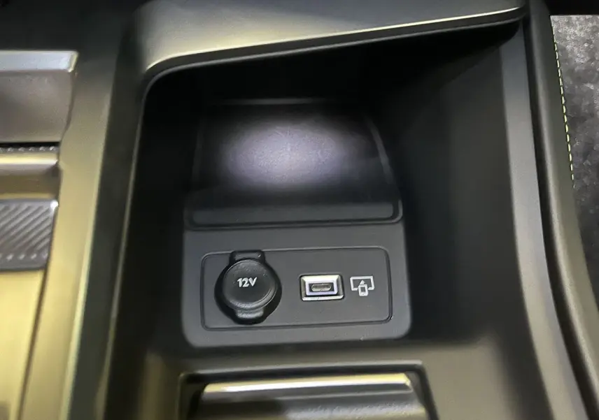 Prise 12V et port USB en gros plan dans la console centrale de la Peugeot 308 GT PHEV blanc nacré.
