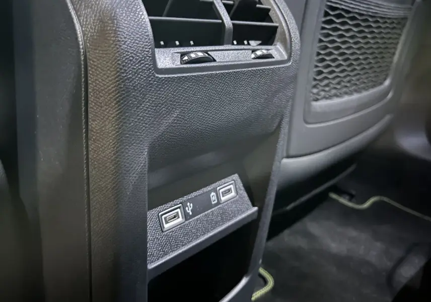 Vue rapprochée de la console arrière noire de la Peugeot 308 GT PHEV avec deux ports USB visibles.