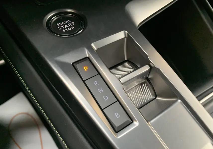 Gros plan sur la console centrale de la Peugeot 308 GT PHEV 2022, montrant les boutons de sélection de boîte auto et le bouton start/stop.