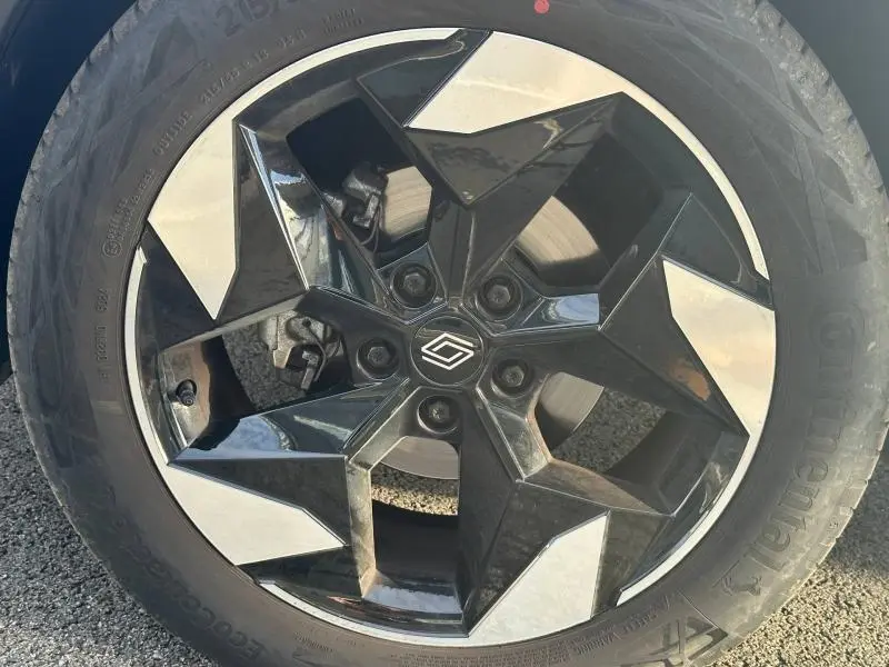 Gros plan sur la jante noire et argentée du Renault Captur 2025 Rouge Flamme/Noir Etoilé, mettant en valeur son design géométrique.