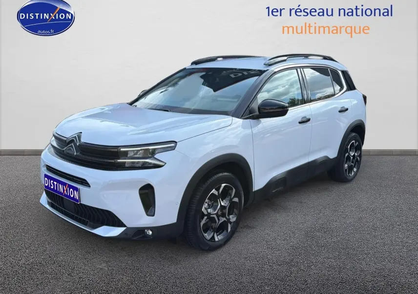 Citroën C5 Aircross blanc vue 3/4 avant droit avec jantes alu et barres de toit noires.