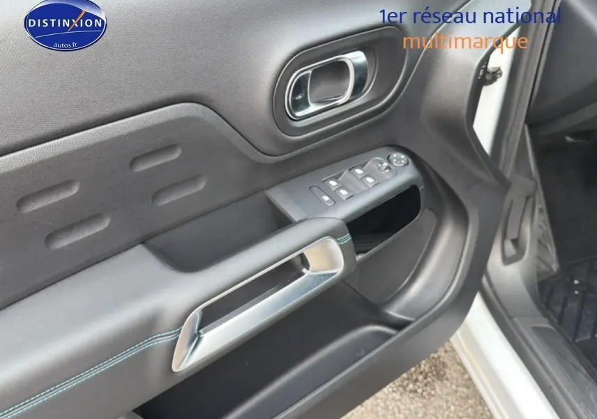 Détail de la porte avant gauche noire avec poignée chromée et commandes des vitres sur Citroën C5 Aircross blanc.