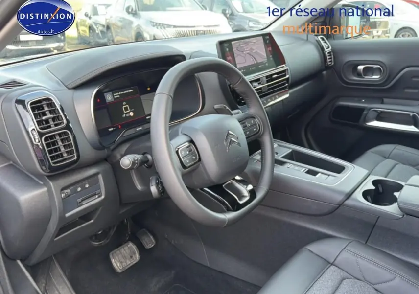 Intérieur avant droit du Citroën C5 Aircross blanc 2025 avec volant cuir multifonction et écran tactile GPS.